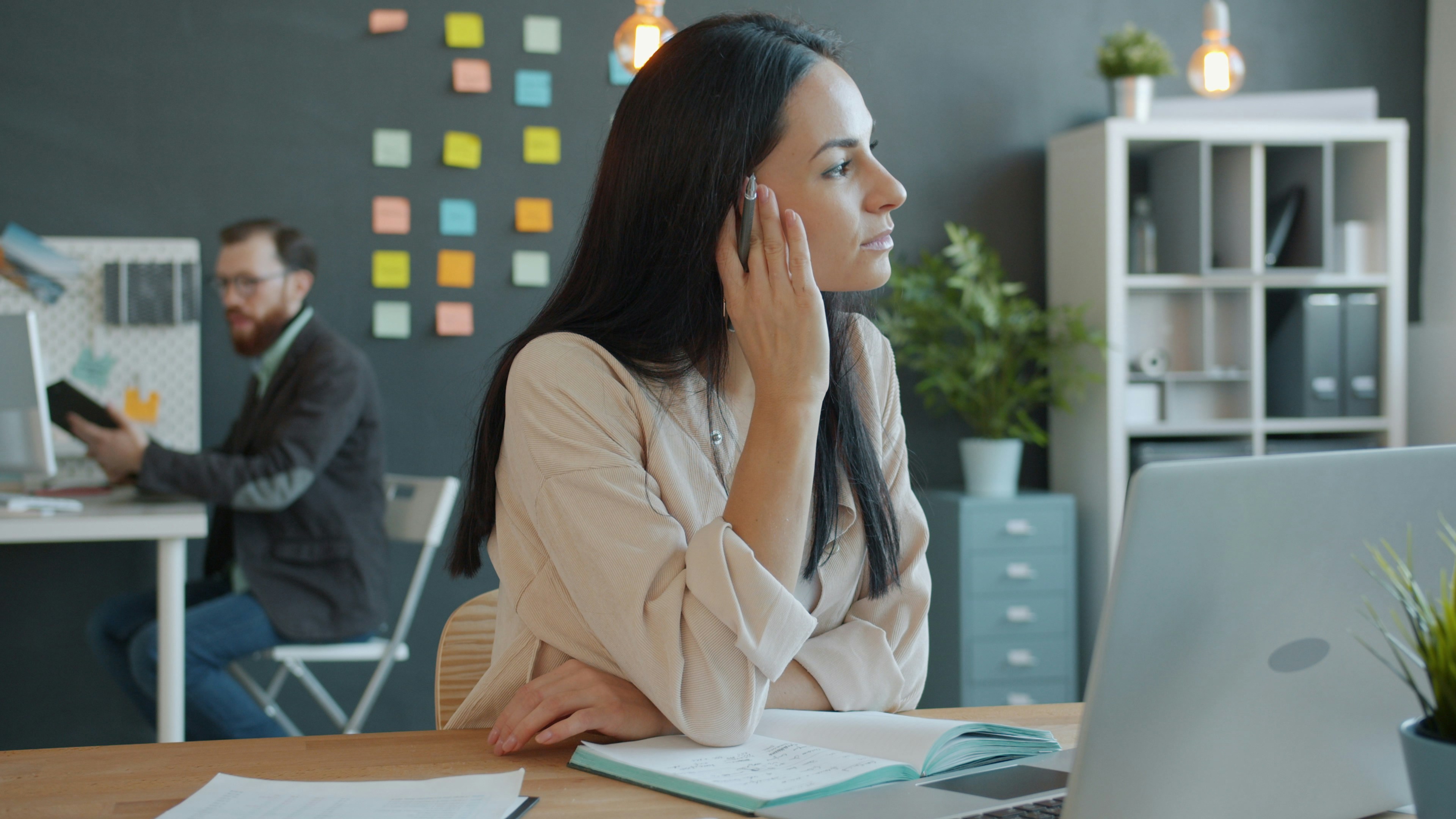 A focused professional contemplating her EPROLO dropshipping business strategy at her desk in a modern shared office.