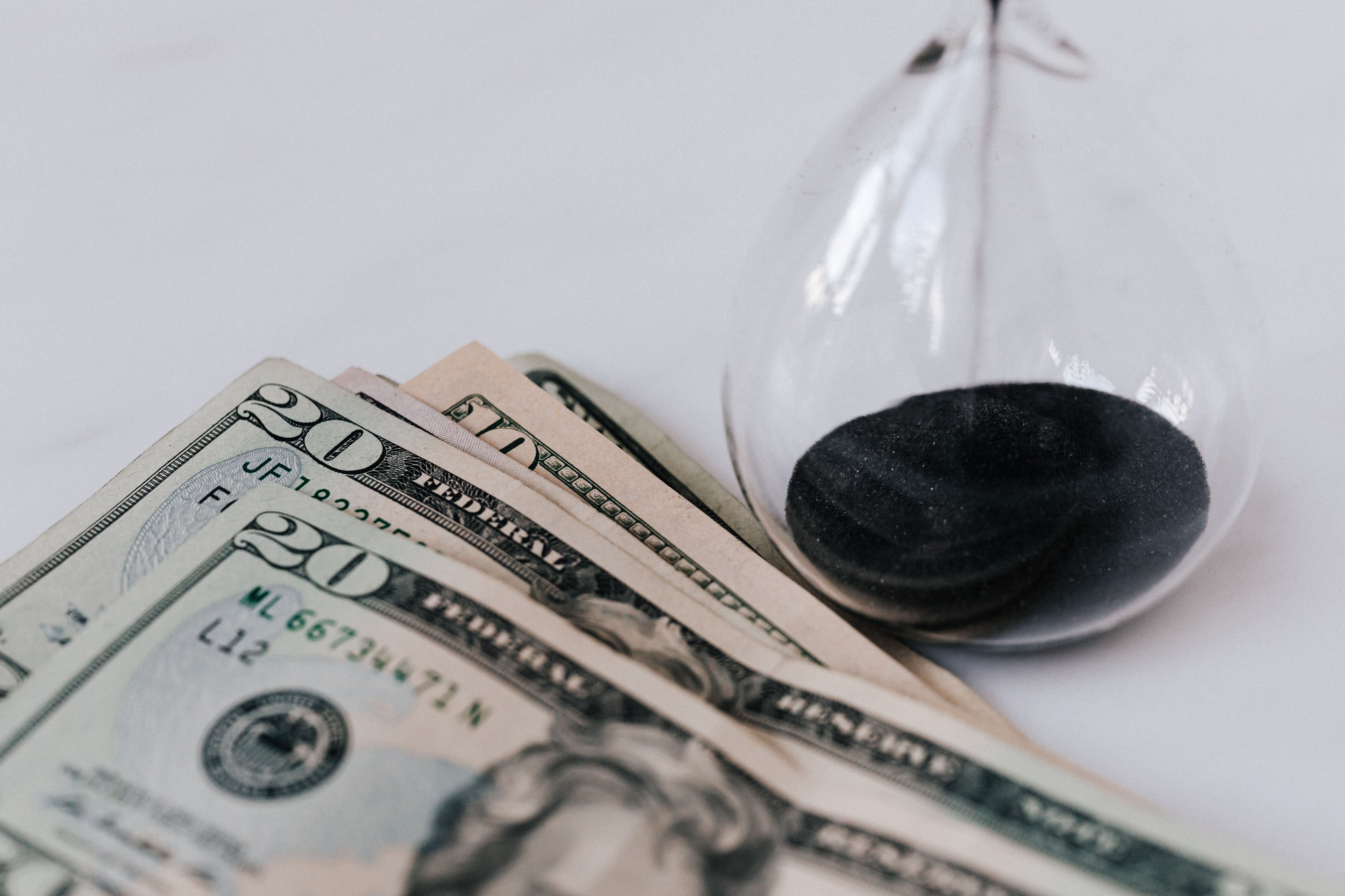 An hourglass next to dollar bills, illustrating how to cut clothing return rates efficiently with EPROLO.