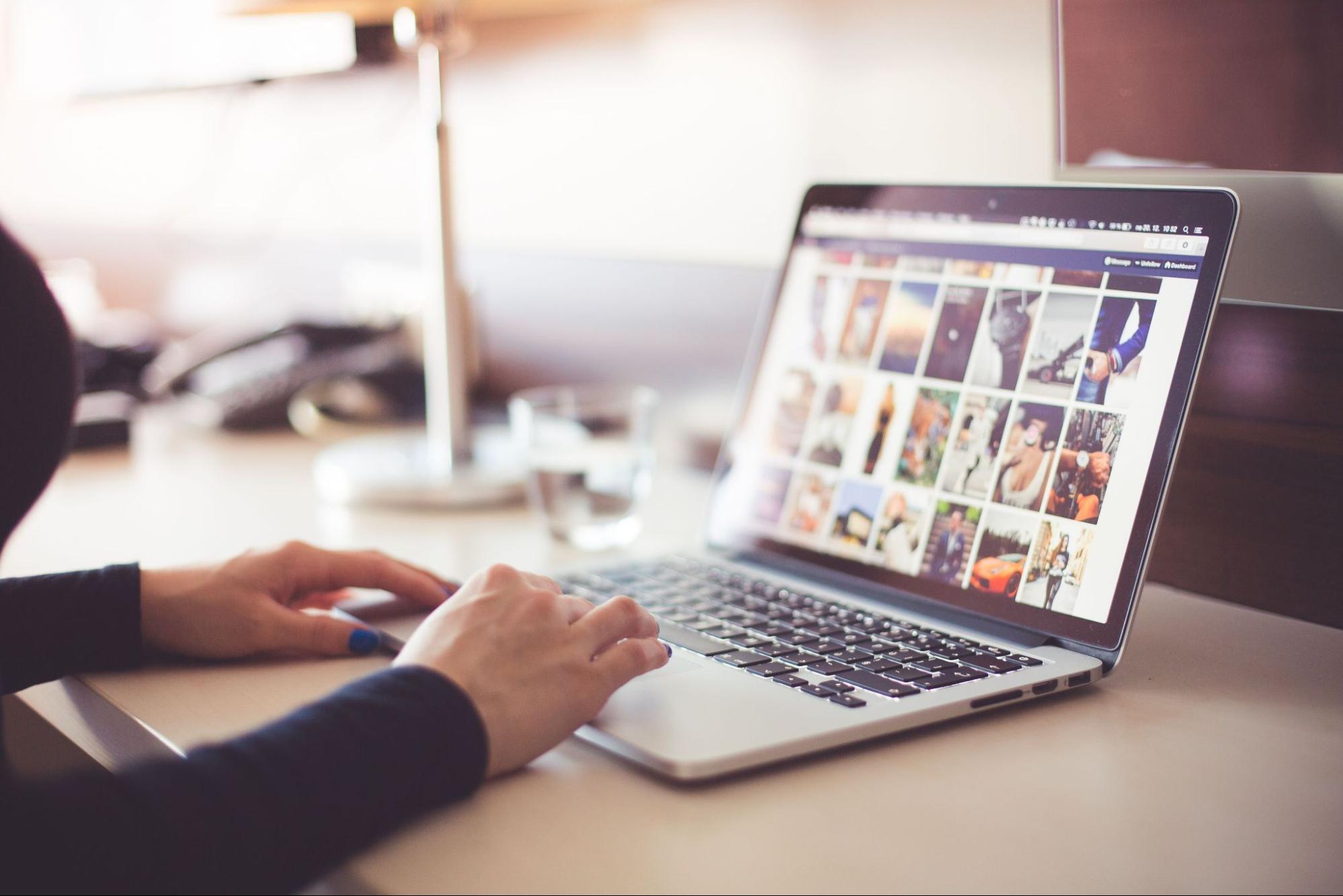 A person typing on a laptop to learn how to boost Etsy sales using EPROLO at a desk setup.