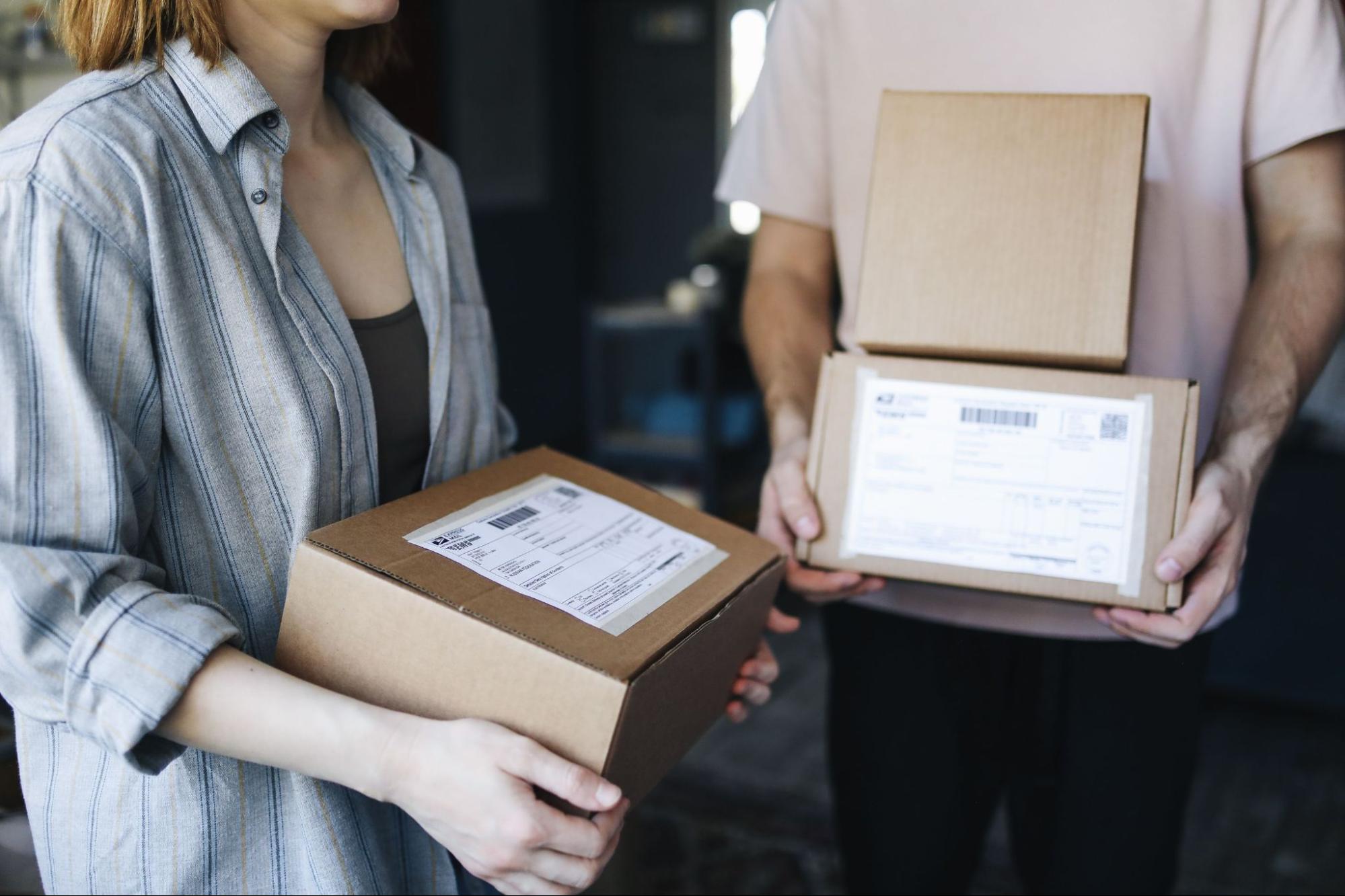 Two people holding cardboard package boxes for dropshipping fulfillment