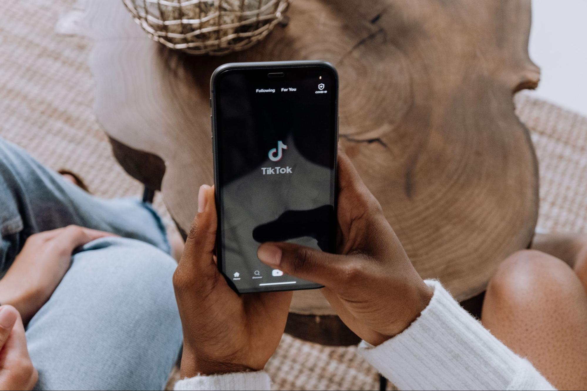 A person holding a smartphone on TikTok to drive TikTok Shop organic growth with EPROLO.