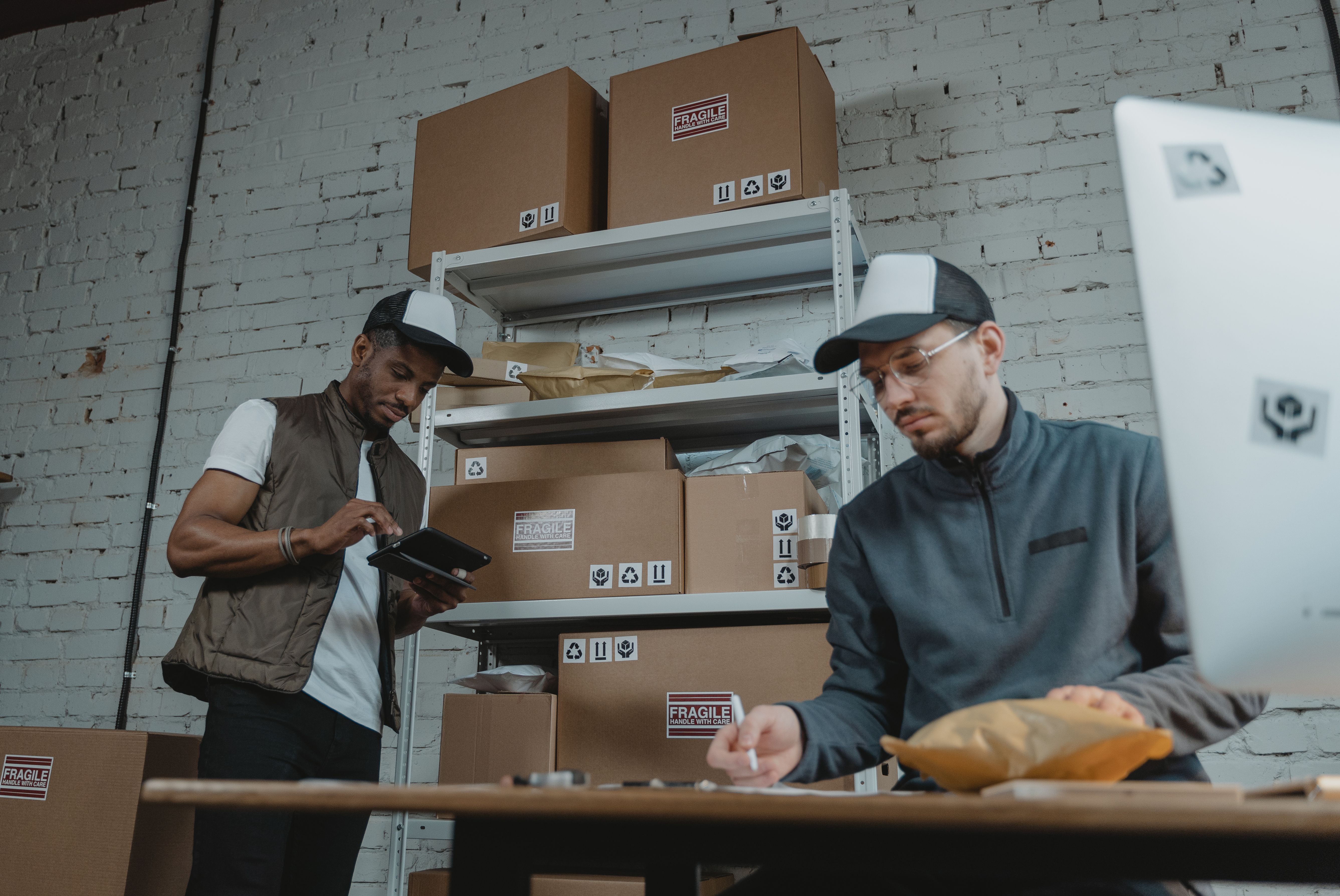 Warehouse workers performing dropshipping quality control with EPROLO while inspecting parcels.