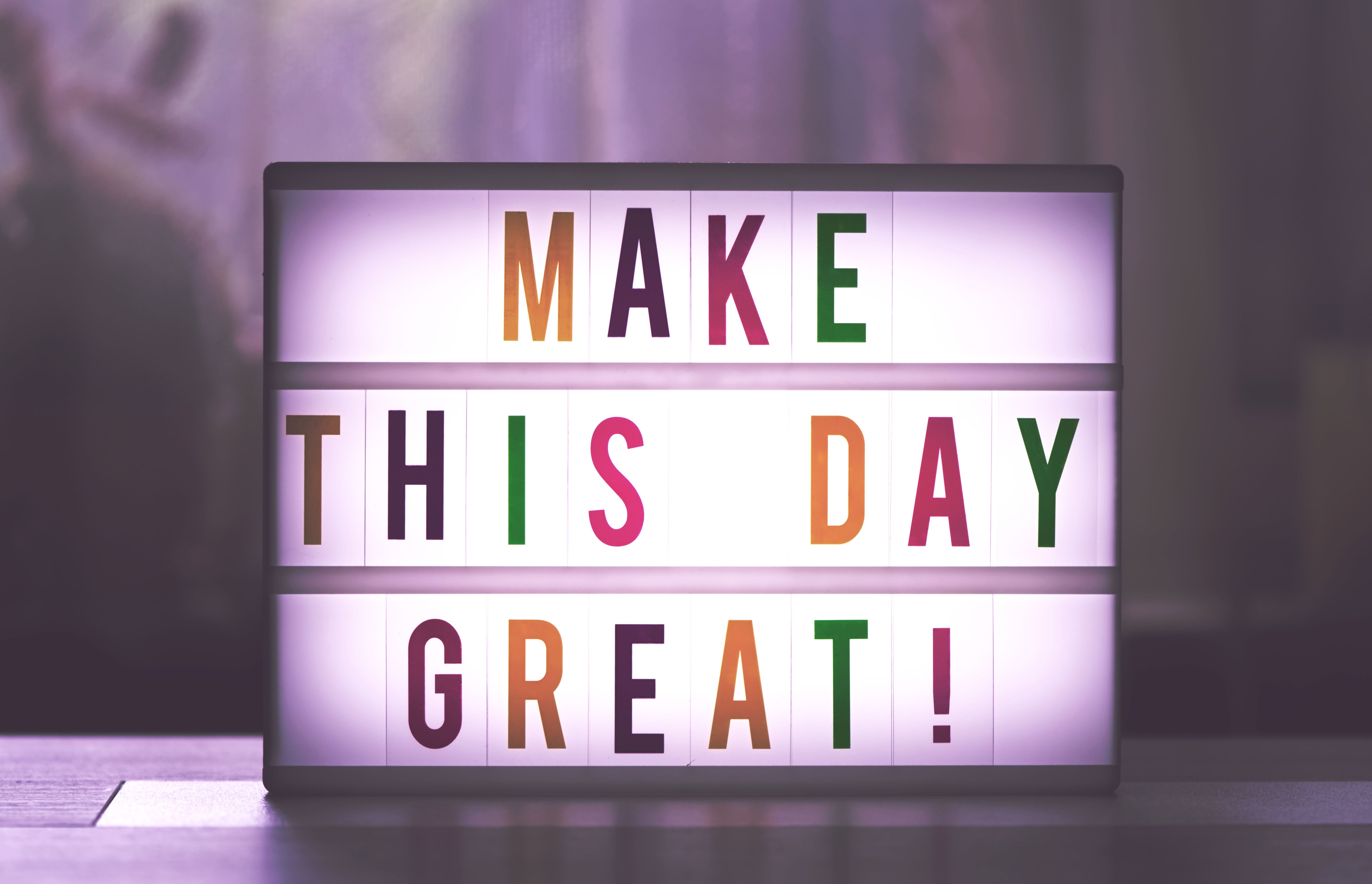 Displaying daily motivational quotes on an illuminated lightbox reading Make This Day Great.