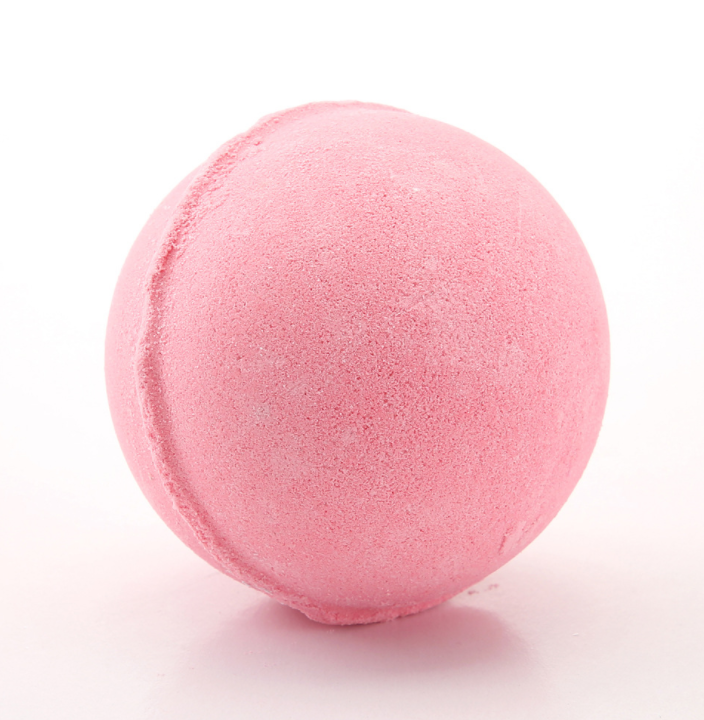 Close-up of a single bubblegum pink bath bomb on white background