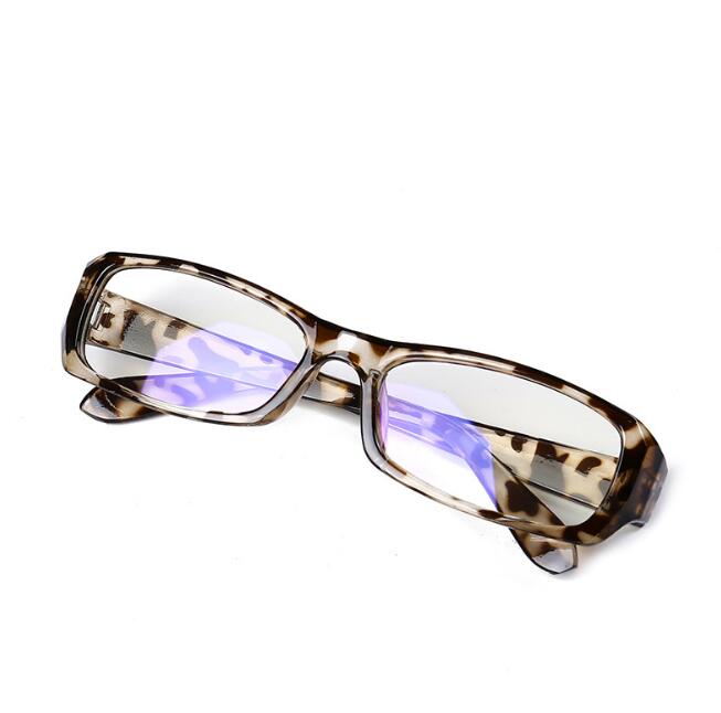 Tortoiseshell frame glasses with blue‑tinted lenses next to a screen, filtering visible light