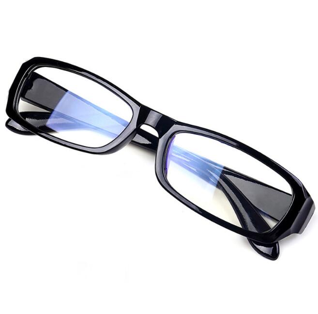 Black rectangular computer glasses with blue light filtering lenses shown at angle on pale apricot suede backdrop