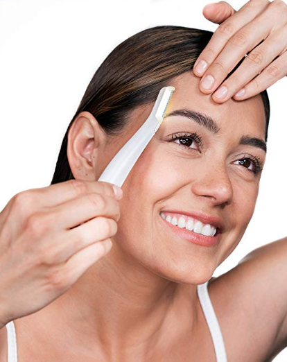 Woman using facial tool along her cheek