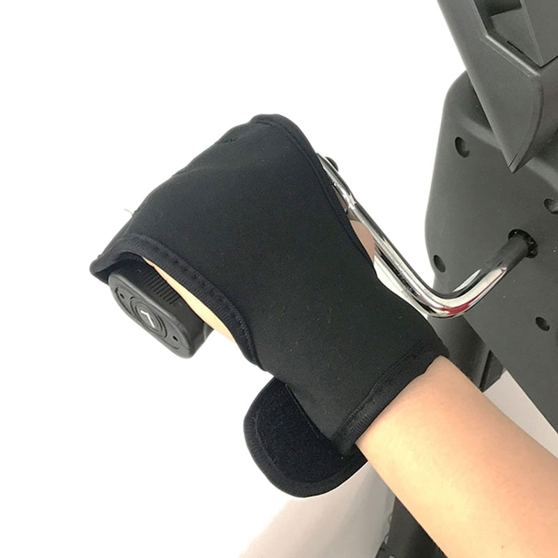 Hand brace glove fitted on hand gripping black exercise bike handle