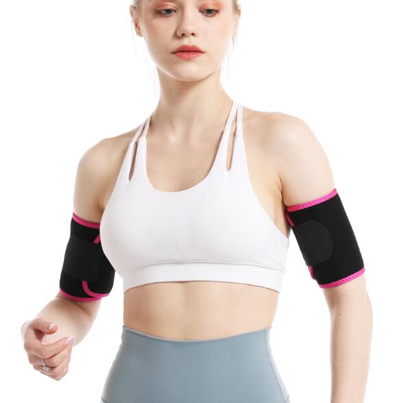 Upper body detail of woman wearing white sports bra with black and pink arm band shaper sleeves