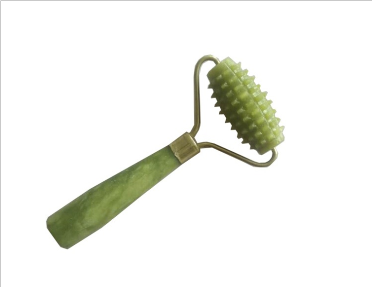 Close-up of textured massage roller head in green jade with brass ferrule