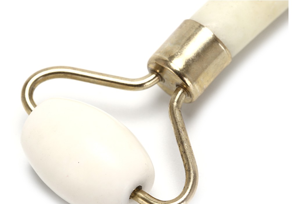 White jade dual-head roller with brass metal ferrule and matching handle detail