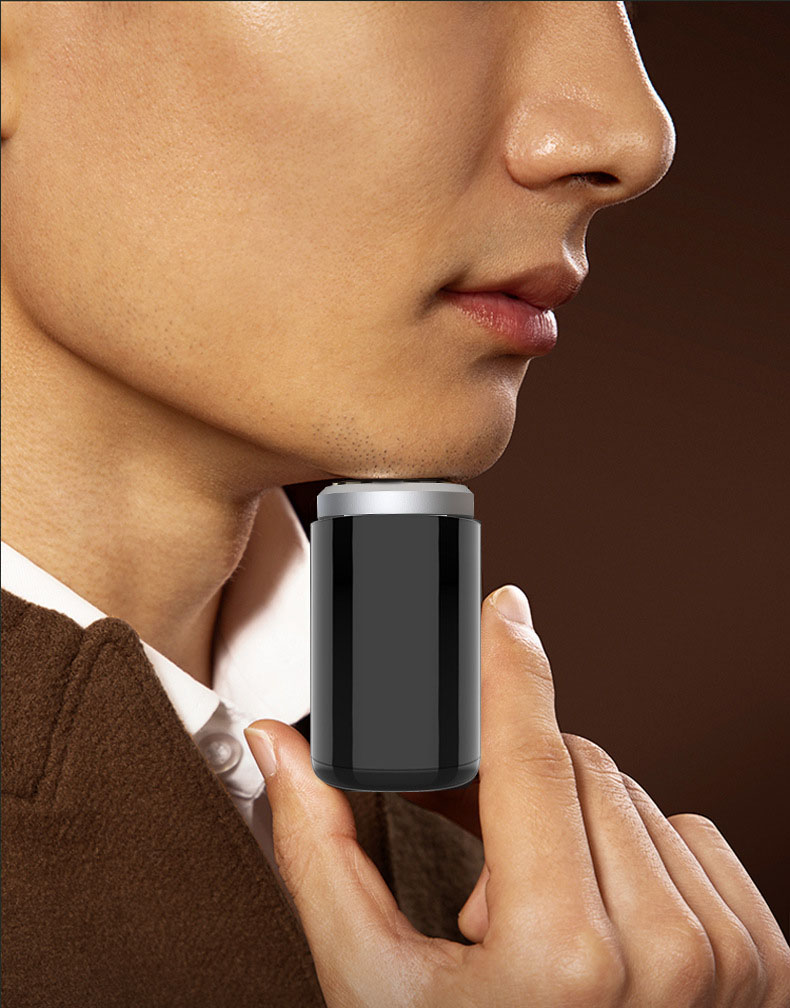 Man using compact black shaver in brown suit