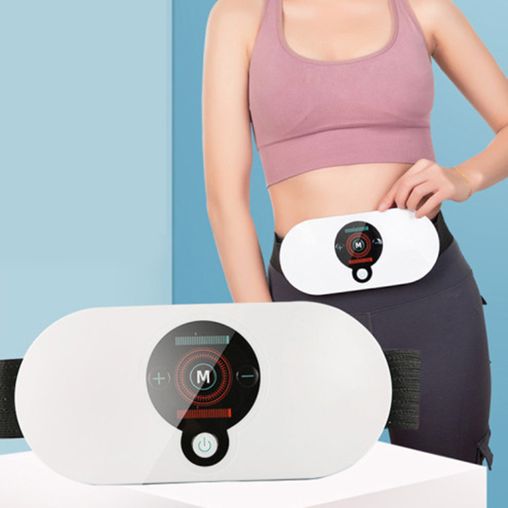 Fit woman in pink sports bra and black leggings holding waist massager at hip level against blue background