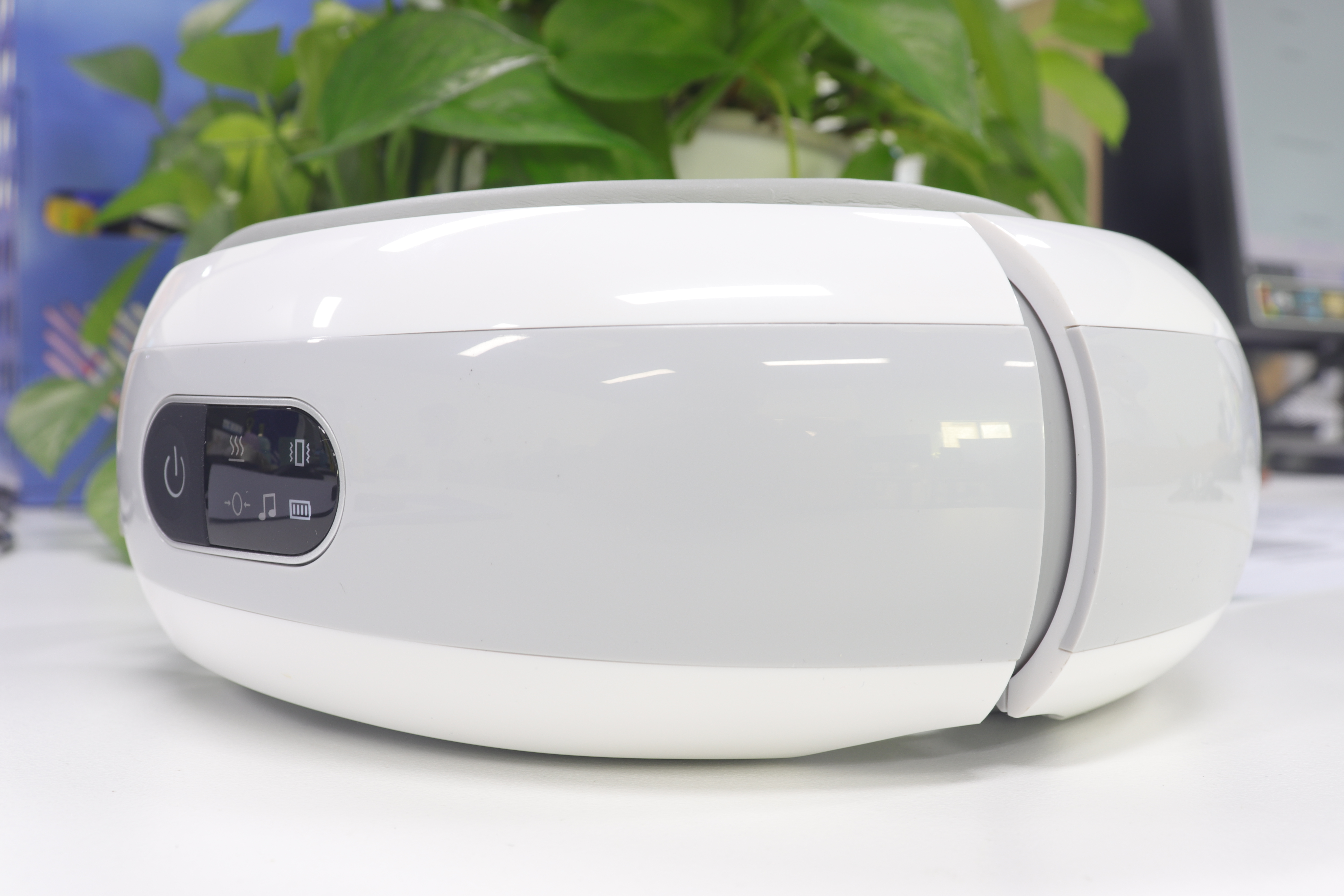 Eye massager placed near a desk with plants and soft home lighting