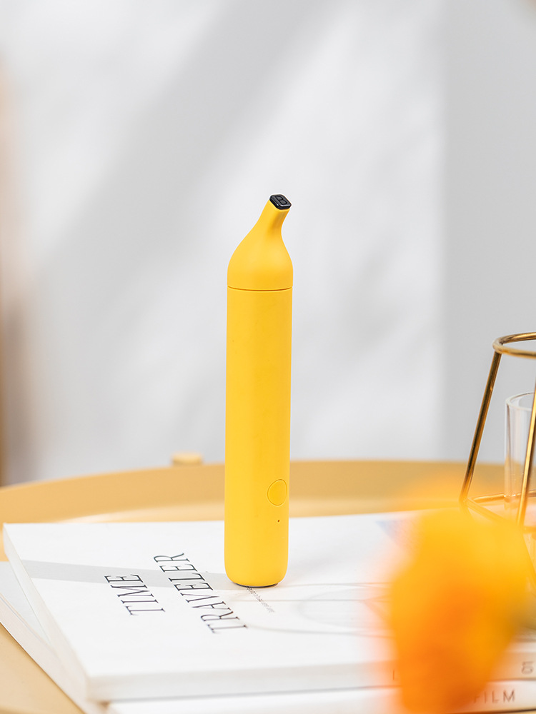 Bright yellow banana-shaped anti-itch pen on white desk with notebook, showcasing vibrant color and compact design