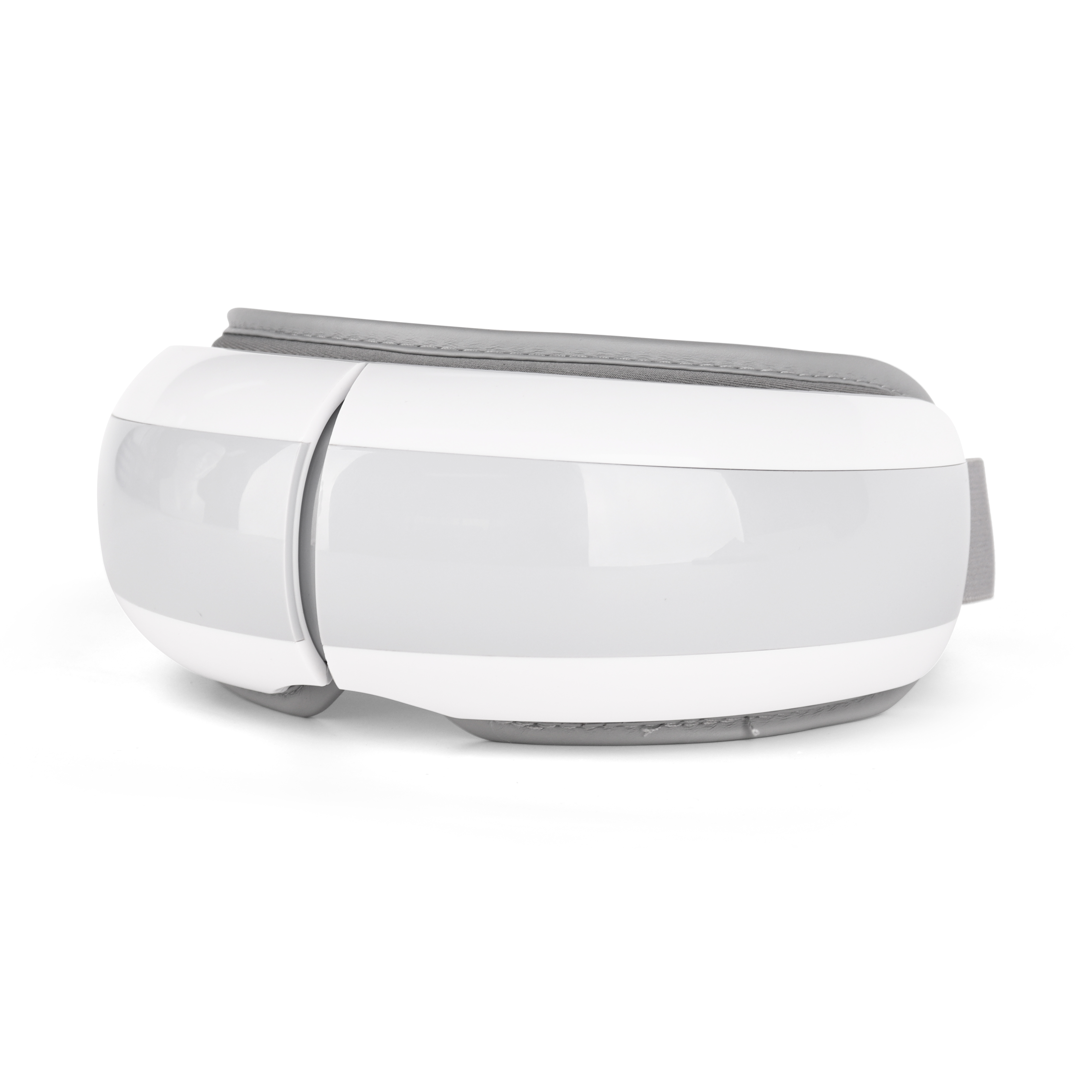 Top-down view of compact oval eye massager with adjustable elastic strap, shown against a light surface