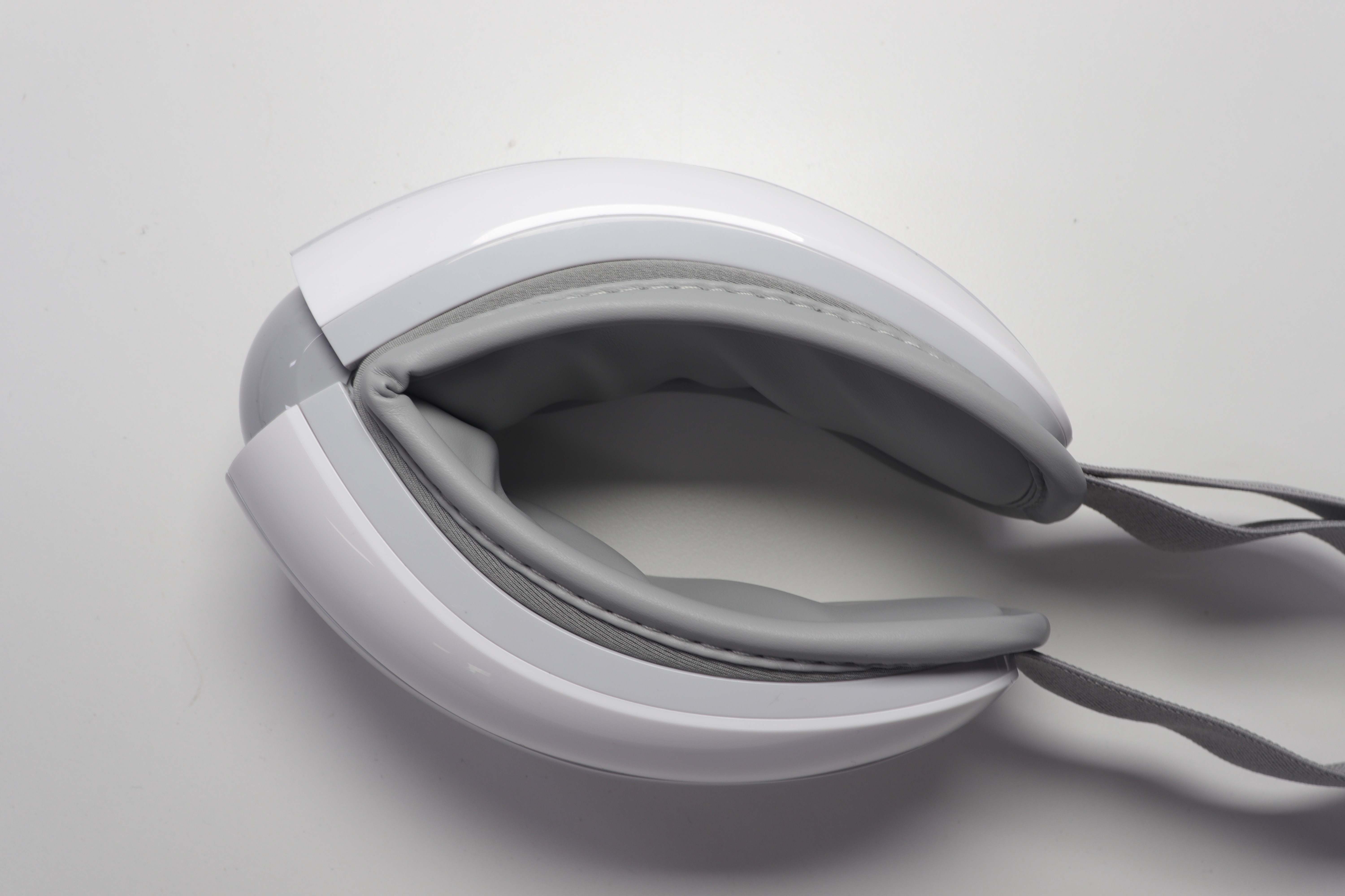 Side view of eye massager revealing three-layer airbag chambers and soft interior padding