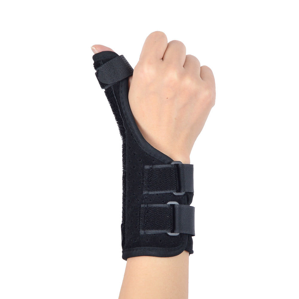 Black wrist brace with thumb support worn on a hand, showing adjustable strap system from a side angle