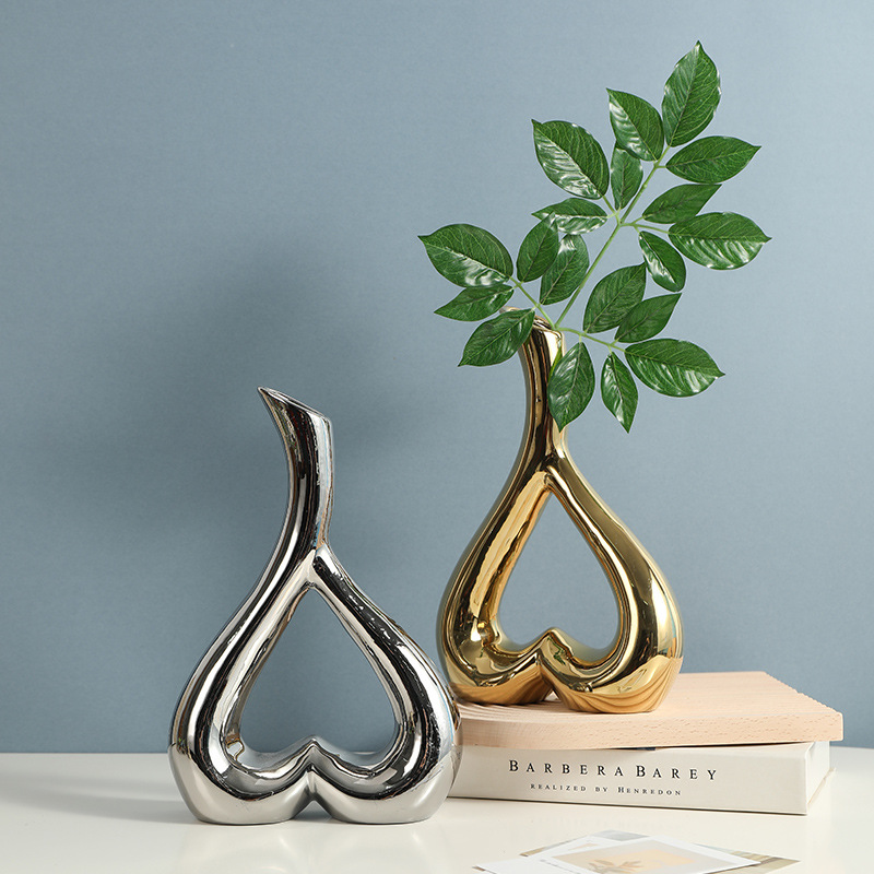 Metallic heart vase holding decorative branches