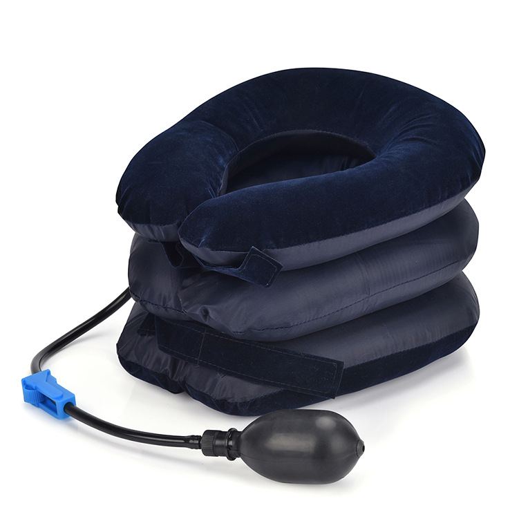 Inflatable cervical traction device on soft white bouclé fabric, showing three-layer construction and navy velvet exterior with burgundy strap.