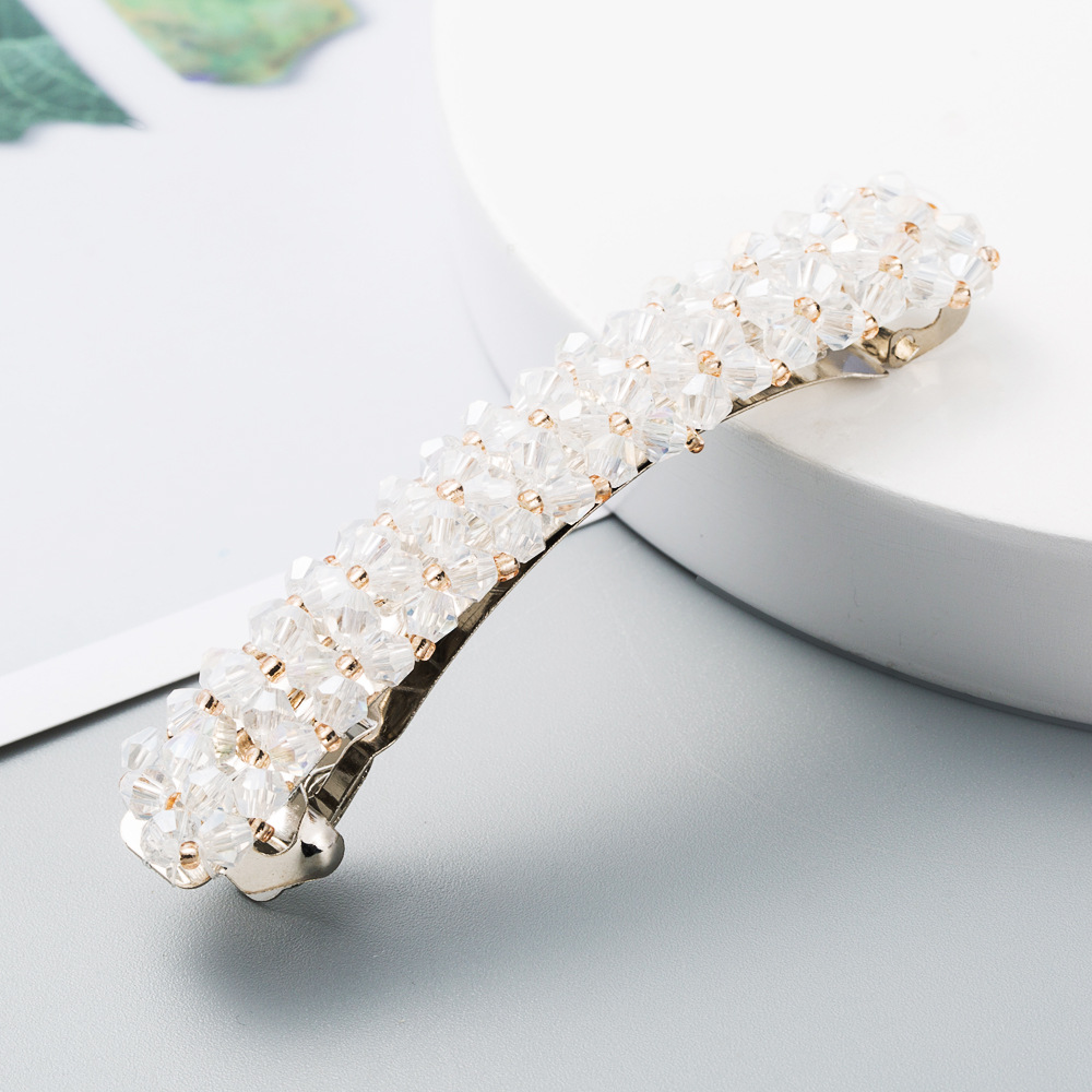 Faceted beads reflecting light on a clear gold clip