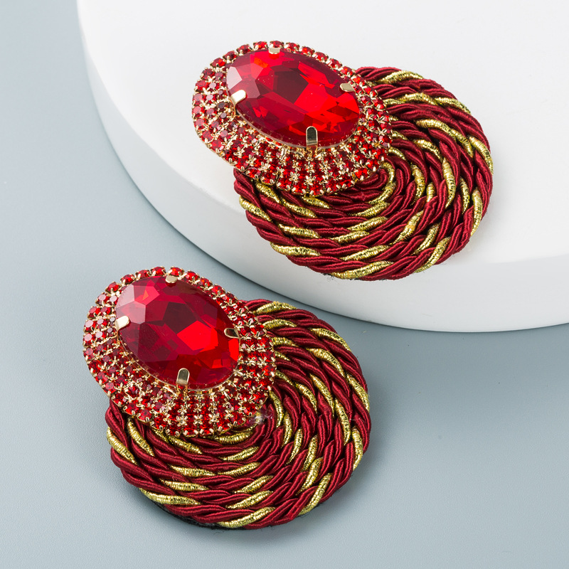 Ruby red earrings showing twisted metallic braided construction