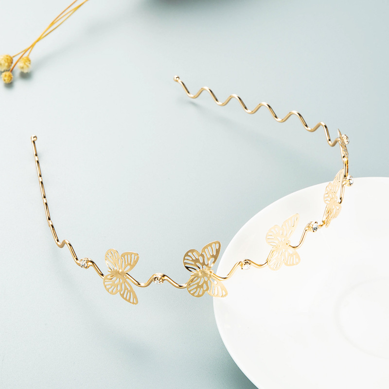 Wavy gold metal hoop with butterfly and botanical motifs