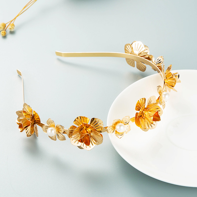 Wearable gold floral hoop displayed beside a white plate