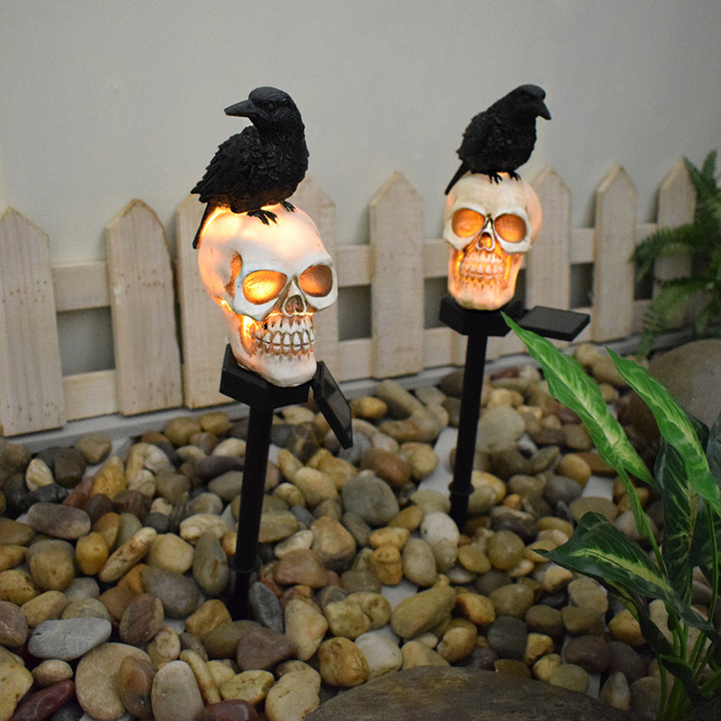 Illuminate your outdoor space with the daring Raven on Skull Solar Yard Lighting. This striking light features a raven perched atop a skull, casting an eerie glow powered by solar energy.