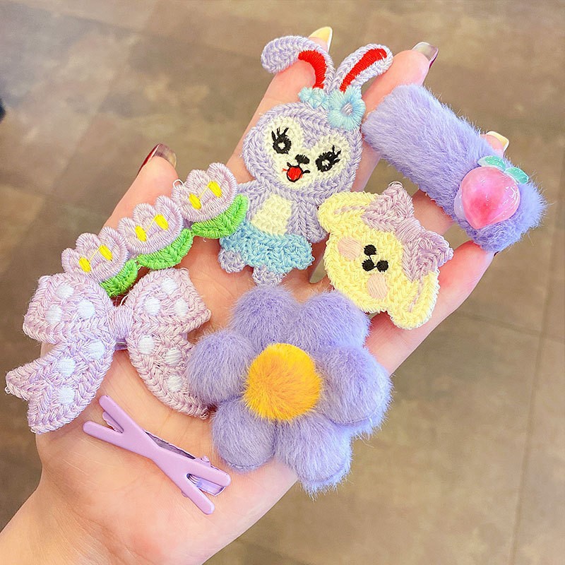Compact plush clip resting on an open hand