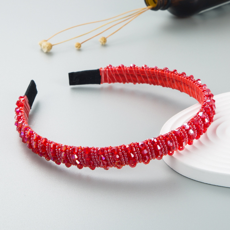 Glossy red beads woven across headband surface
