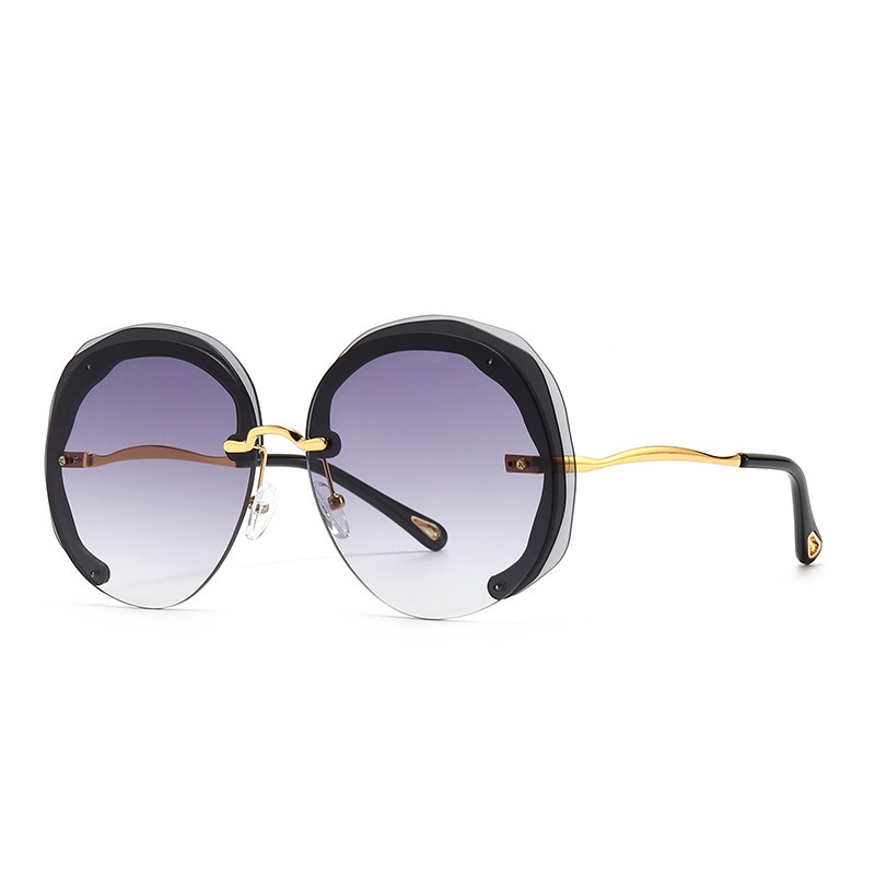 Gold-toned bridge and curved temples on smoky black sunglasses