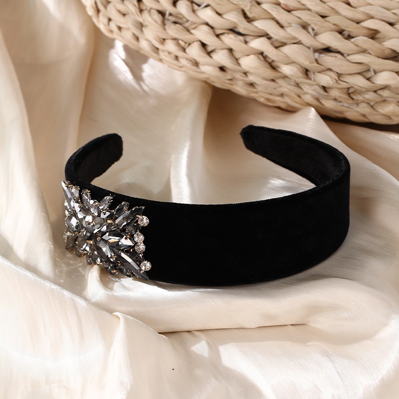Wide black headband resting beside a woven basket