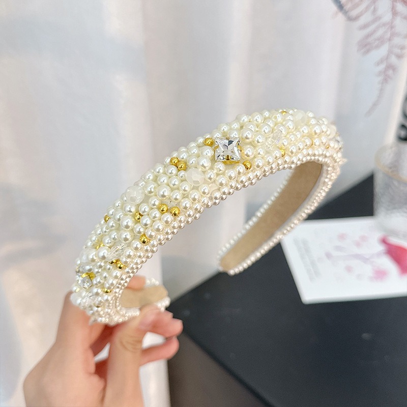 Cream padded headband with ornate gold pearl details