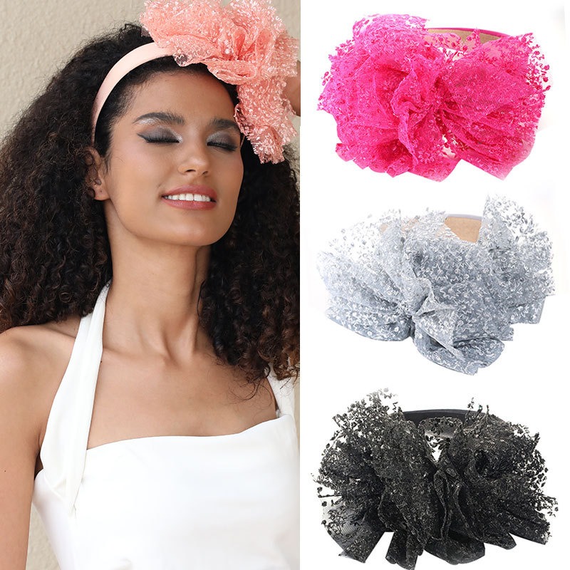 Model wearing layered embroidered lace bow headband