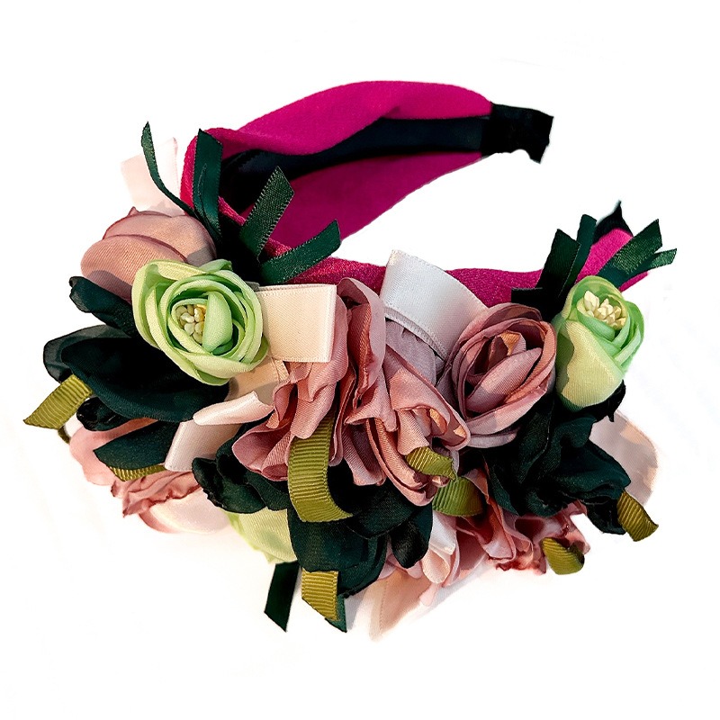 Layered handmade flowers with leaf and ribbon accents
