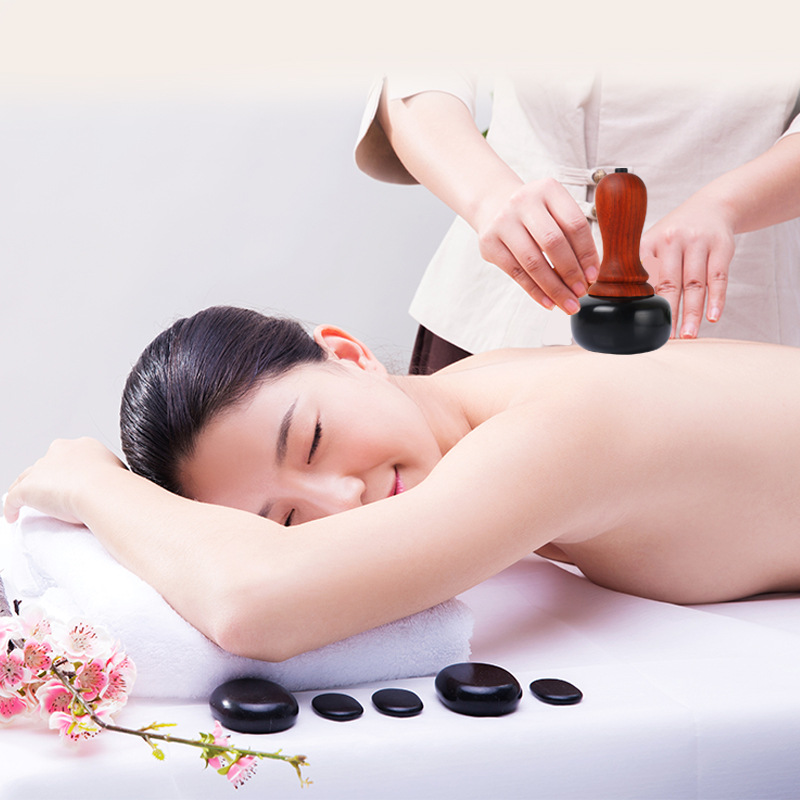 Woman in spa receiving heated bian stone massage on back, visibly relaxed