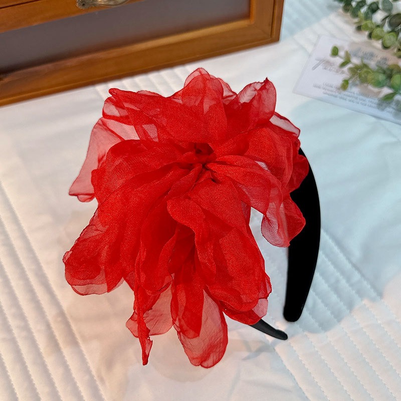 Red oversized flower headband showing ruffled petal layers