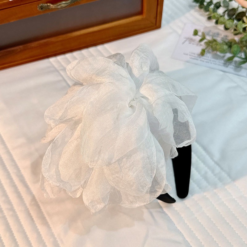 Ivory flower headband showing smooth curved black base