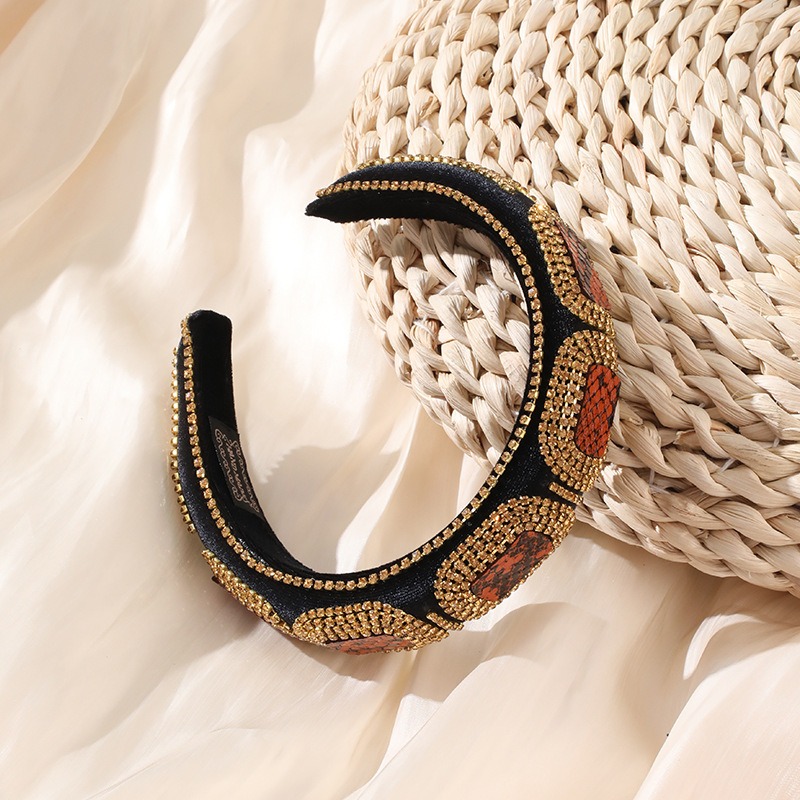 Wide padded jeweled headband styled beside woven basket