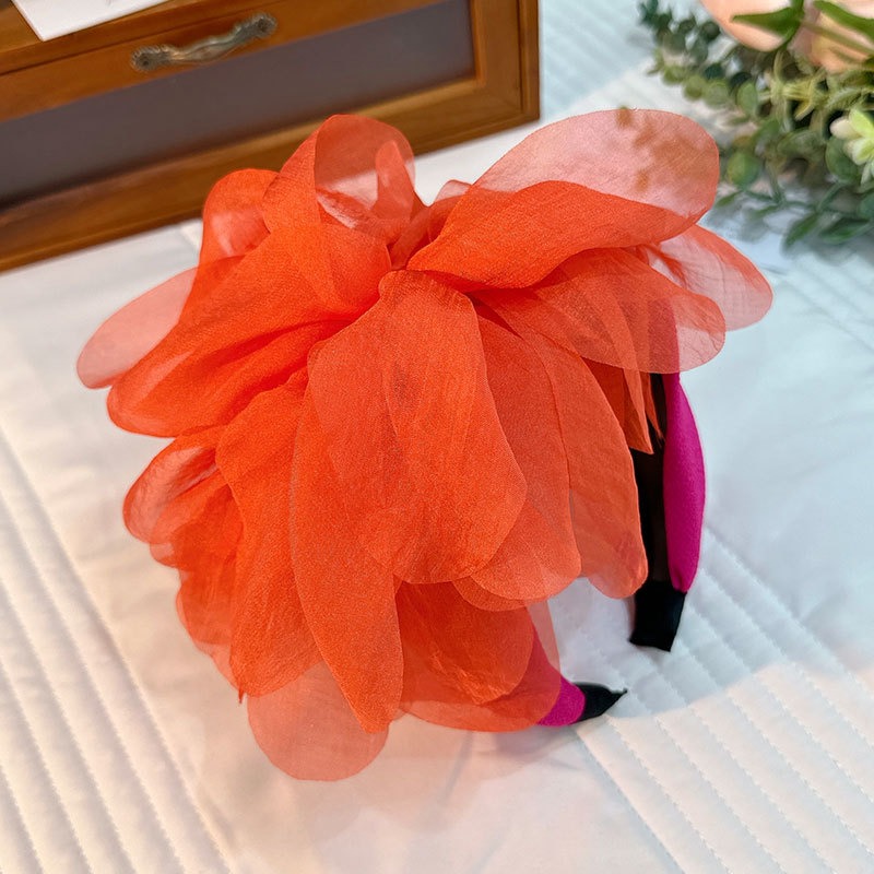 Orange flower headband showing translucent overlapping petals