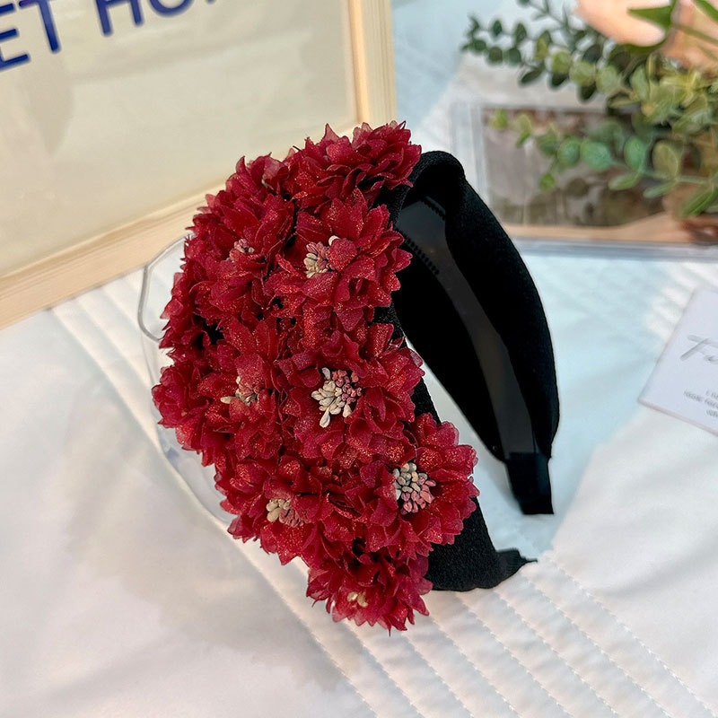 Close view of densely layered burgundy fabric flowers