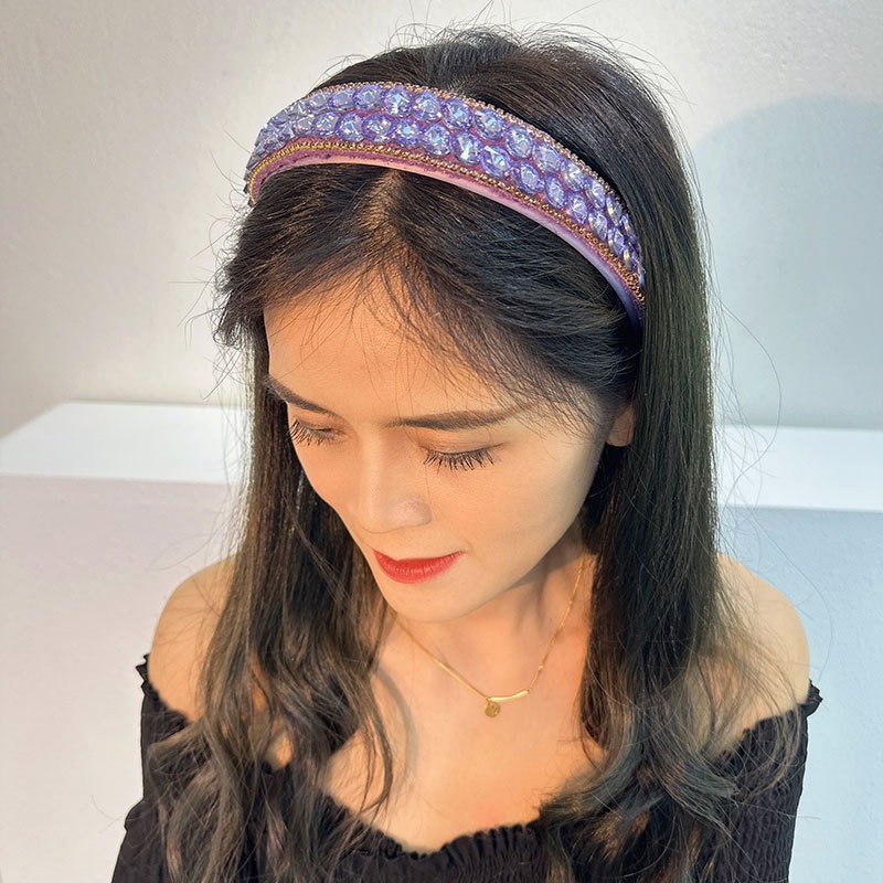 Purple rhinestone headband worn with long dark hair