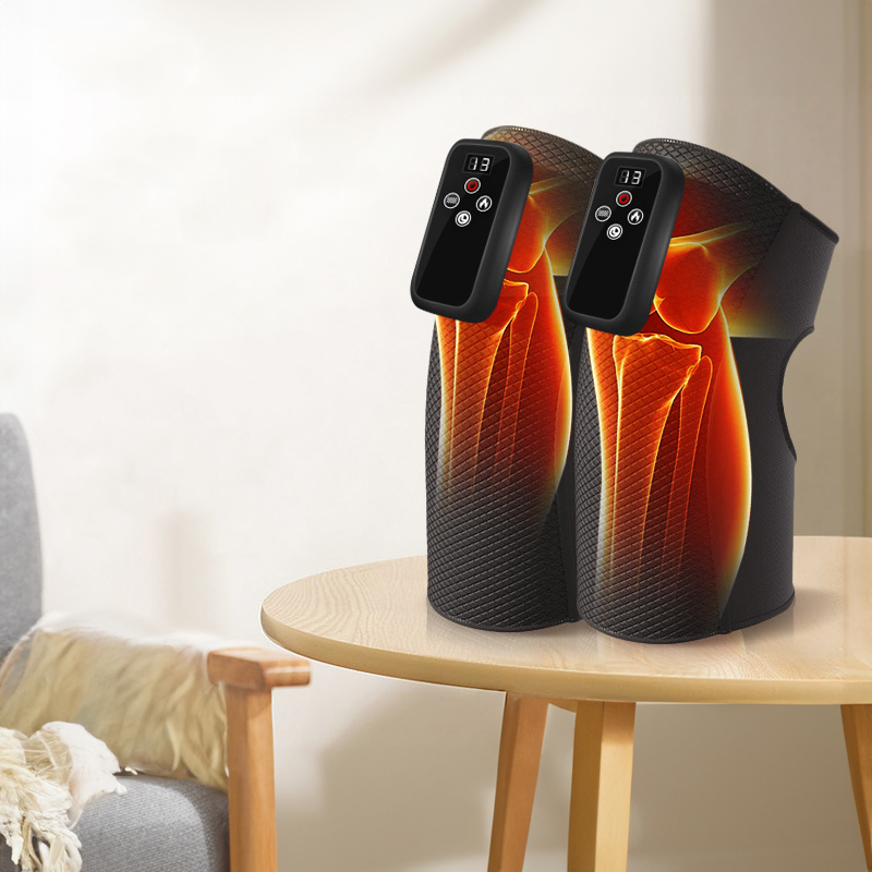 Two heating knee massagers with digital display and glowing heat visualization on a light wooden table in a bright room
