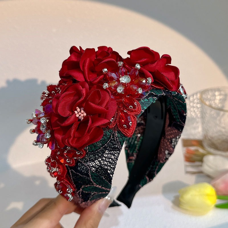 Red rhinestones and beads catching light around layered flowers