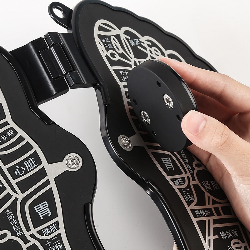 Close-up of hand holding mat edge, revealing textured silicone surface and metal contact points