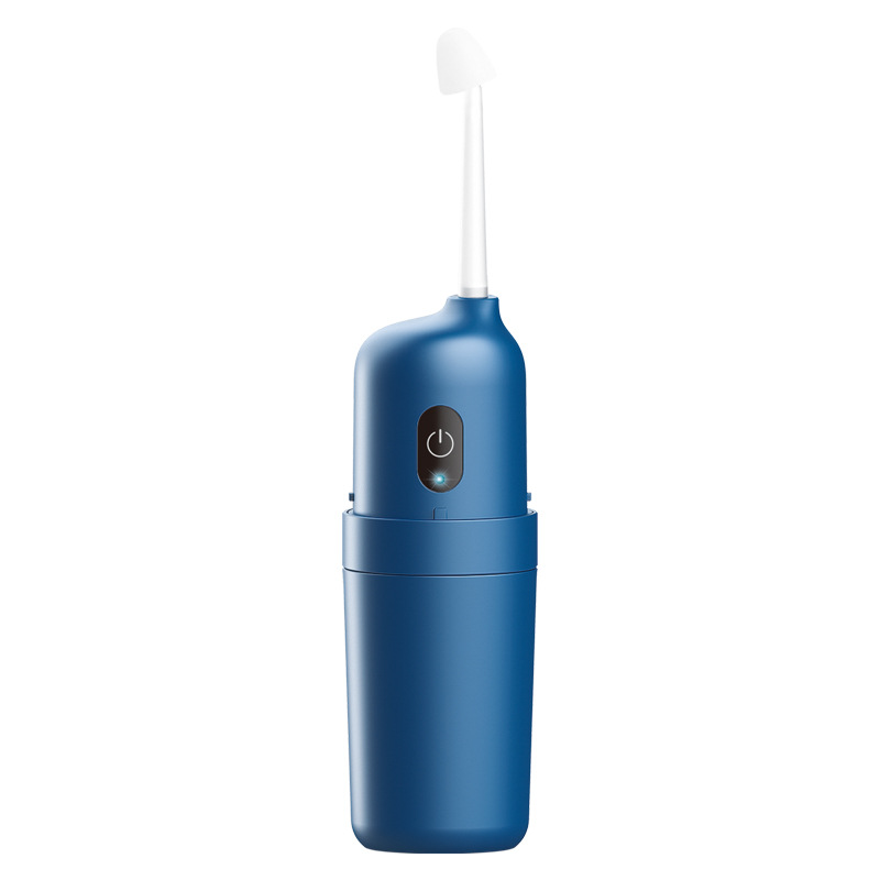 Blue electric nasal washer with white curved applicator on warm sand travertine stone with eucalyptus sprig, editorial off-center composition
