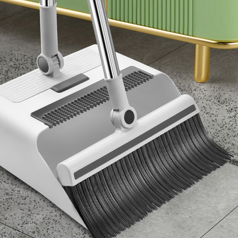 Folding broom collapsed flat against a wall for compact storage