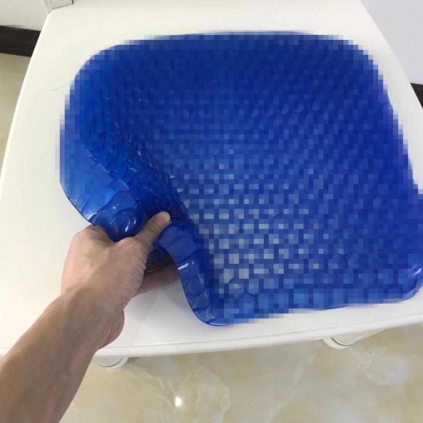 Close-up of hand holding flexible gel cushion showing bendability and gel material