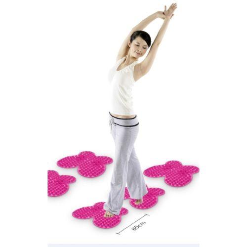 Woman performing a standing yoga pose with pink Futzuki mats arranged beneath her feet, demonstrating relief and improved posture